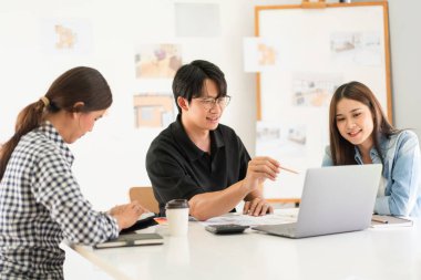 Construction design concept, Architects team is look house plan on laptop to discussing together.