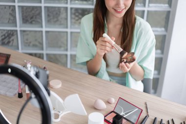 Güzellik blogcusu kavramı, genç kadın Vlog 'a başvurmak ve gözden geçirmek için sıvı fondöten kullanıyor.