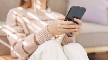 Boş zaman kavramı, akıllı telefondan müzik dinlerken kulaklık takan kadınlar..