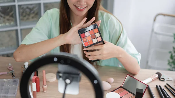 Beauty Vlogger concept, Young woman show eyeshadow to presenting product and record video for Vlog.