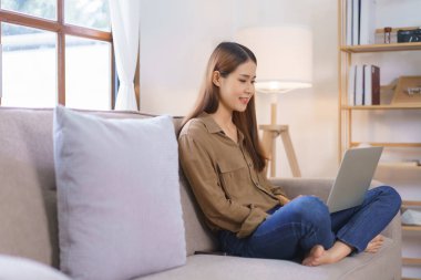 Ev kavramında çalışan kadın serbest yazar, iş verilerini okur ve dizüstü bilgisayarda mali rapor yazar.