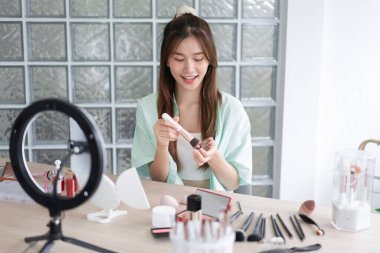 Güzellik Etkilendirici Konsepti, genç kadın, Vlog 'a başvurmak ve gözden geçirmek için sıvı fondöten kullanır.