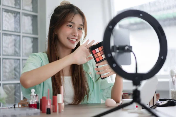 Beauty blogger concept, Young woman show eyeshadow to presenting product and record video for Vlog.