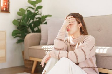 Dinlenme zamanı konsepti, kadınlar yerde oturuyor ve acı çeken alnına dokunuyorlar..