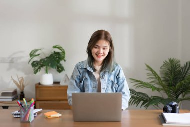 Yaratıcı tasarım konsepti, kadın tasarımcı çevrimiçi düzen için istemciyle bağlantı kurmak için dizüstü bilgisayarda çalışıyor.