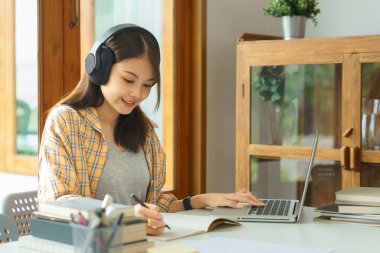 Eğitim ve okur yazarlık kavramı, üniversiteli kız çevrimiçi ders dinliyor ve notlar alıyor..