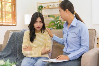 Terapi görürken depresyondaki hastayı rahatlatmaya çalışan bir kadın psikolog..