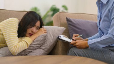 Depresyonda olan kadın hastalar kanepeye uzanıp psikologların seans terapilerini dinliyorlar..