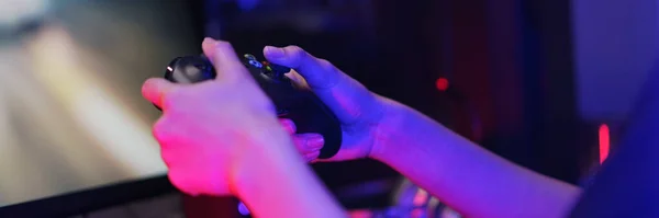 Hand of female cyber hacker gamer holding controller joystick to playing games on computer.