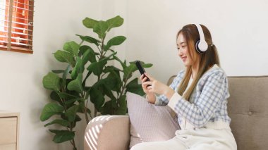 Dinlenme zamanı konsepti, kanepede oturan ve film izlerken kulaklık takan kadınlar..