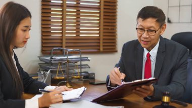 Yasalar ve adalet kavramı, kıdemli avukat sözleşmeyi işaret ediyor ve kadın avukatla görüşüyor..