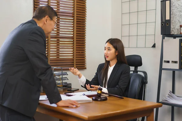 Law and justice concept, Female lawyer showing contract to explains and consults with senior lawyer.
