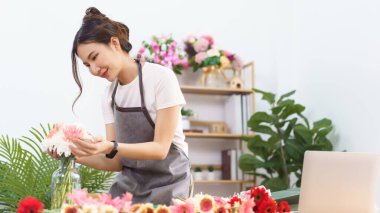 Çiçekçi konsepti, çiçekçi kadın vazoda renkli çiçekler, çiçekçi dükkanında da mutluluk..