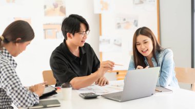 Construction design concept, Architects team is look house plan on laptop to discussing together.