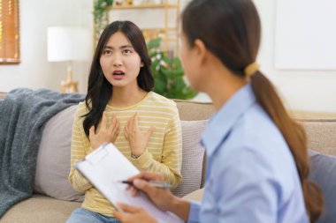 Panoya notlar yazarken zihinsel sorununu psikologla paylaşan kadın hastalar..