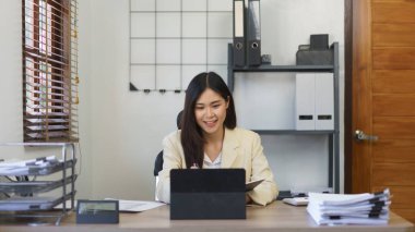 Sekreter konsepti, kadın sekreter not defterine not alıyor ve tabletten rapor okuyor..