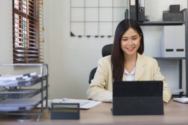 Sekreter konsepti, kadın sekreter tablet üzerinde çalışıyor ve iş raporunu daktilo ediyor.