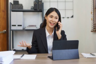 Sekreter konsepti, kadın sekreter iş verilerini yöneticilere açıklamak için telefonda konuşuyor..
