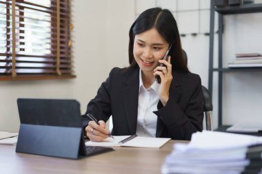 Sekreter konsepti, kadın sekreter patronla telefonda konuşuyor ve not defterine not alıyor..