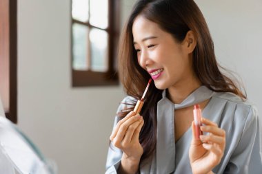 Güzellik blogcusu dudaklarına ruj sürüyor ve makyaj vlog makinesindeki kozmetik ürünlerini inceliyor..