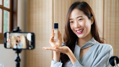 Güzellik blogcusu makyaj vlogger için akıllı telefondan video kaydedilirken gizleyici ürünü gözden geçiriyor.