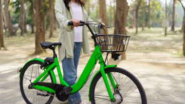 Bisiklet süren ve gezen kadınlar parkta egzersiz yapmak için bisiklet sürdükten sonra dinlenerek eğleniyorlar..