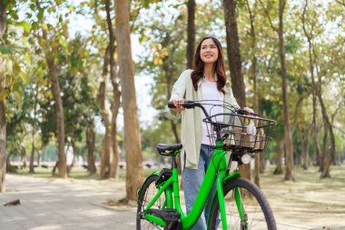 Bisiklet süren ve gezen kadınlar parkta egzersiz yapmak için bisiklet sürdükten sonra dinlenerek eğleniyorlar..