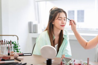 Güzellik ve kozmetik konsepti, makyözün model için kaş ve profesyonel makyaj uygulaması.