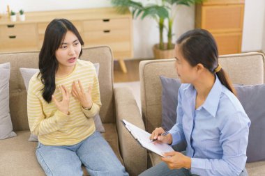 Panoya notlar yazarken zihinsel sorununu psikologla paylaşan kadın hastalar..