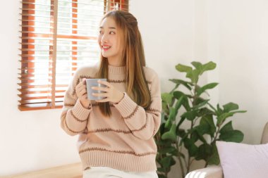 Boş zaman konsepti, kadınlar kahve fincanı tutarken bir şeyler düşünür ve pencereden dışarı bakarlar..