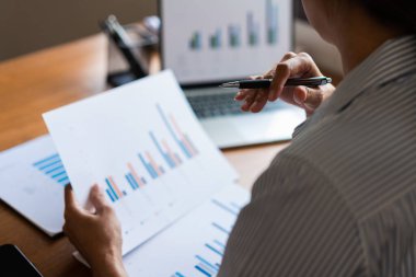 İş kadınına yakın plan, dizüstü bilgisayar ve iş belgesinde veri okurken strateji düşünüyor.