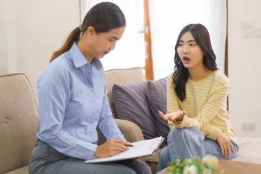 Kadın hastalar psikologa zihinsel sorunlarını açıklarken panoya notlar yazıyorlar..