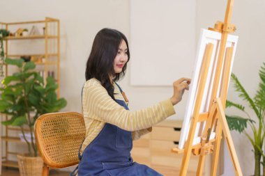 Genç kadın sanatçı hayal gücüdür ve resim yapmak için resim stüdyosundaki sehpada resim yapar..