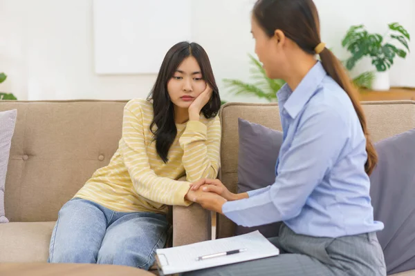 stock image Female psychologist talking and touching hand to comforting depressed patient while session therapy.