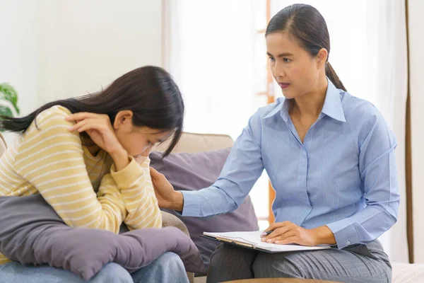 Klinikte seans terapisi görürken kadın psikolog konuşuyor ve depresyondaki hastayı rahatlatıyor..