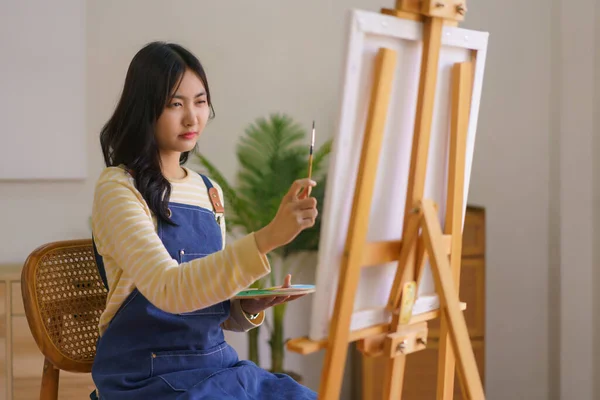 Genç Kadın Sanatçı Fırçayla Orantılı Olarak Stüdyodaki Resim Sehpasında Resim — Stok fotoğraf