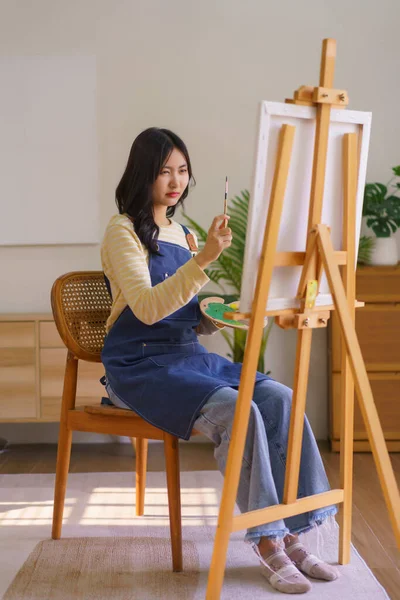 Genç Kadın Sanatçı Fırçayla Orantılı Olarak Stüdyodaki Resim Sehpasında Resim — Stok fotoğraf