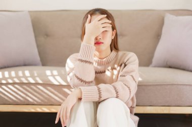 Dinlenme zamanı konsepti, kadınlar yerde oturuyor ve acı çeken alnına dokunuyorlar..