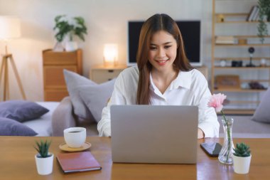 Working at home concept, Women is typing data on laptop while working at modern home office.