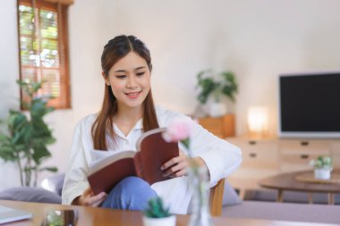 Dinlendirici zaman konsepti, kadınlar modern ev ofisinde dizüstü bilgisayarla çalıştıktan sonra kutsal kitabı okuyor..