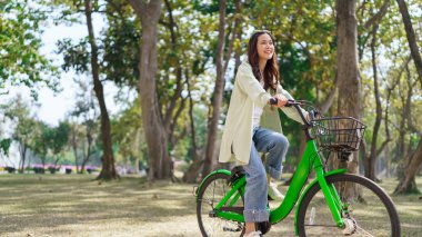 Rahatlamak için bisiklete binen kadınlar ve parkta sağlıklı yaşam tarzıyla egzersiz yapan kadınlar..