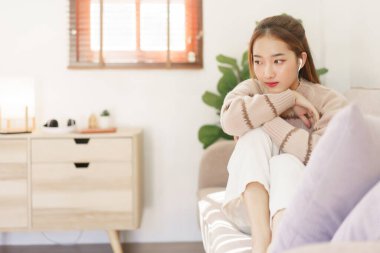 Dinlenme zamanı konsepti, akıllı telefondan müzik dinlemek için kulaklık takan kadınlar..