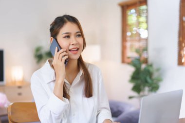 Ev konseptinde çalışan, akıllı telefondan konuşan ve modern ofis bilgisayarında çalışan kadınlar..