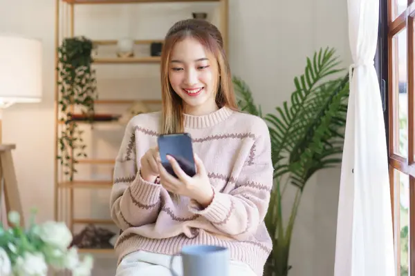 Stock image Leisure time concept, Women use smartphone to surfing social media while relaxation in living room.