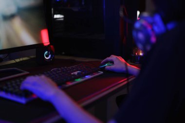 Oyun oynamak veya programlama sistemini hacklemek için klavye ve fare kullanan kadın bilgisayar korsanı.