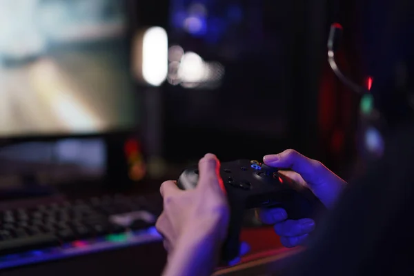 Gaming controller in hands, playing games and online streaming with gamer  competition and esports. Video game tech, streamer person in dark room and  play tournament with joystick and keyboard Stock Photo