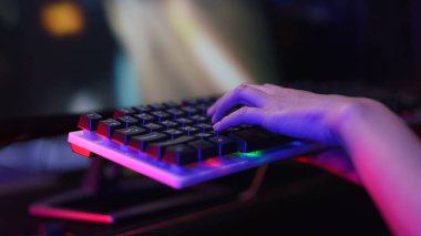 Klavyeye basan ve bilgisayarla oyun oynayan kadın bilgisayar korsanı eli.