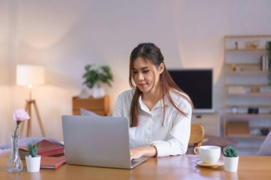 Working at home concept, Women is typing data on laptop while working at modern home office.