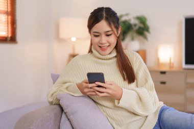 Relaxing time concept, Women sit on couch to surfing social media on phone in modern home office.