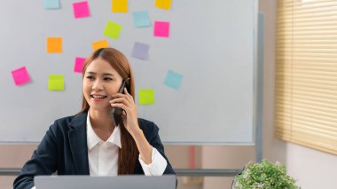 Concept of modern girl leadership, Businesswoman talking on smartphone as looking at data on laptop.